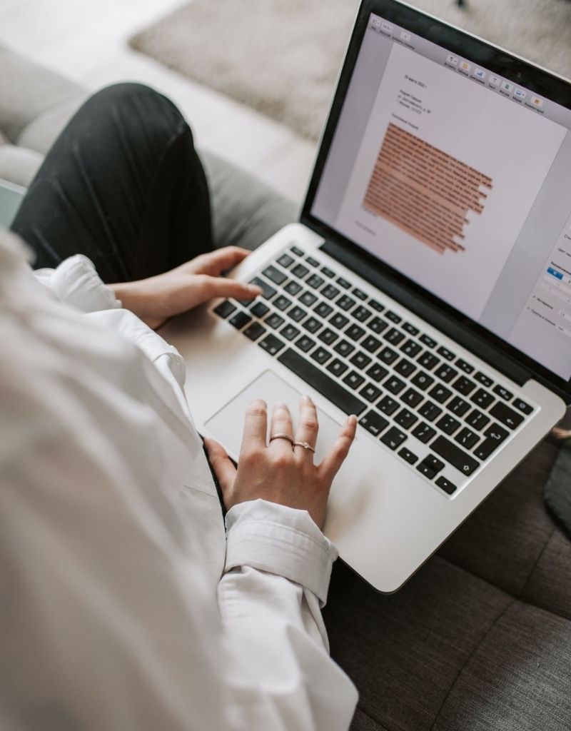 Chica con ordenador portatil mac escribiendo su curso online
