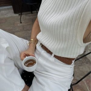 Chica vestida de blanco con café en la mano